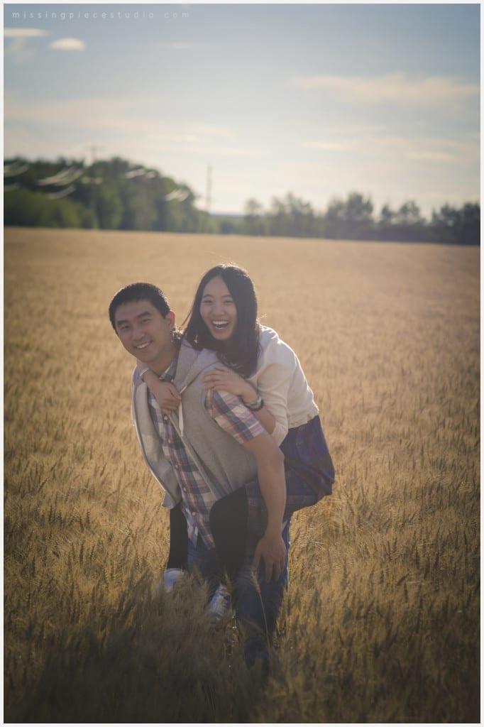 guy gives a piggy back to the girl in a beautiful field