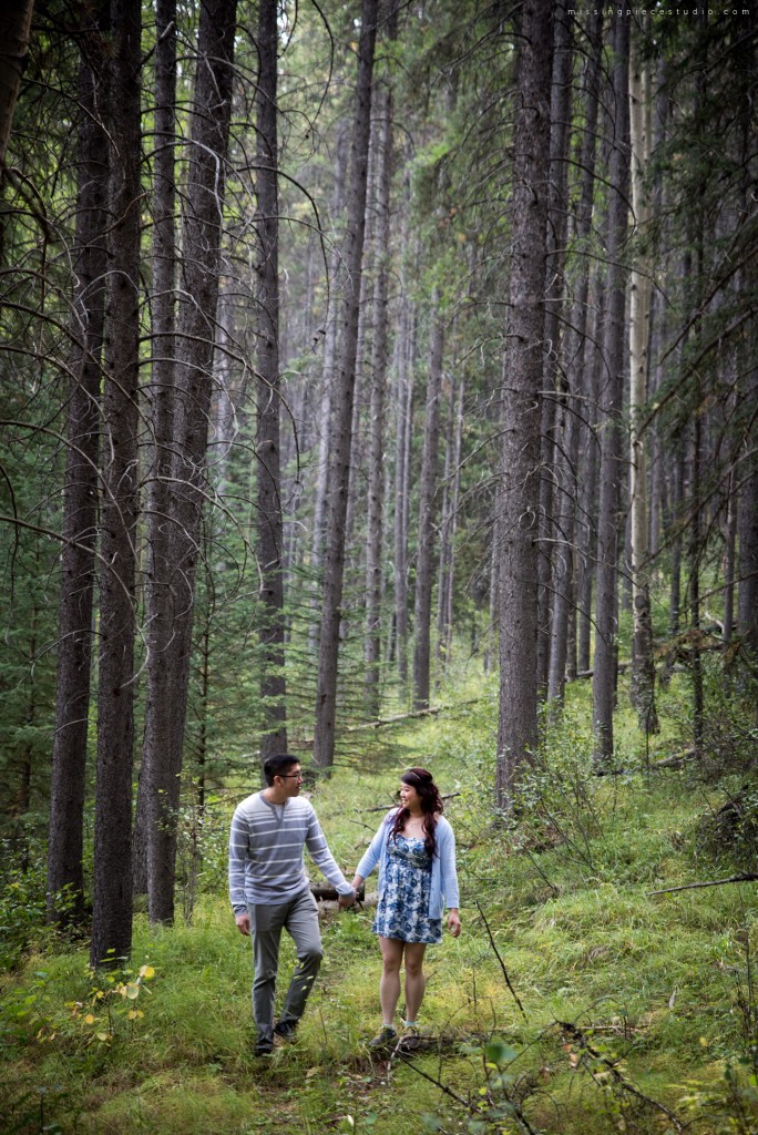 A couple running down the Banff forest in the summer near Calgary Canada